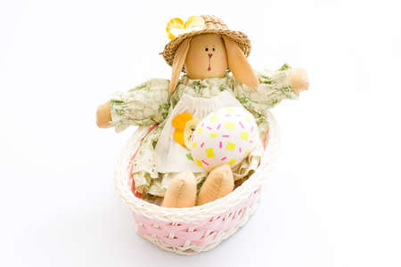 Easter Bunny toy in a pink basket with egg on white background. Easter decoration concept