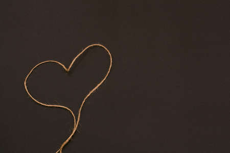 heart of rope on a black background. festive background for Valentine's day, birthday, holiday, party, wedding. Flat lay.の写真素材