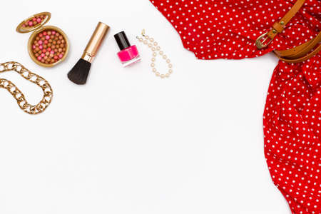 flat lay feminine clothes and accessories on white background. red dress, makeup brush, nail Polish, pearl bracelet. Top view.の写真素材