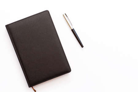 black diary and pen on a white background. minimal business concept. Top view. Flat layの写真素材