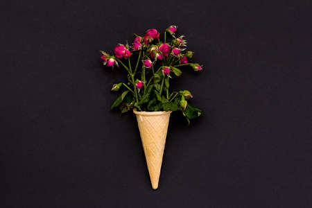 dried flowers roses in a waffle cone on a black background. Flat lay. Top view.の写真素材