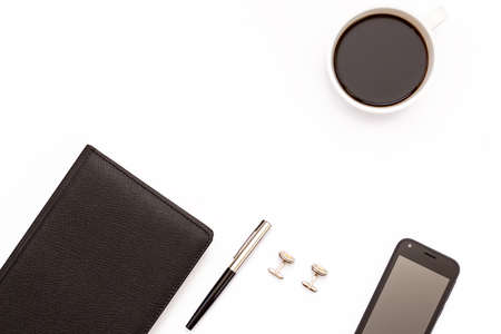 black diary, cufflinks, pen, smartphone and Cup of black coffee on a white background. Minimal concept workplace for business men. Flat lay. Top view.の写真素材