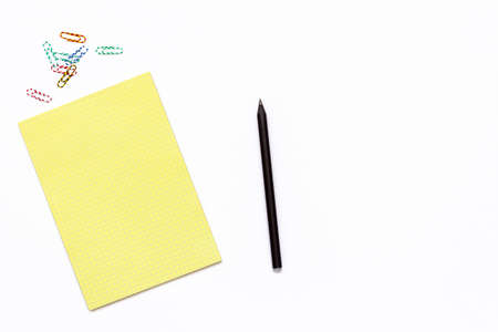 yellow Notepad, a pencil and a paper clip. Minimal business concept of working place in the office. Top view. Flat lay.の写真素材