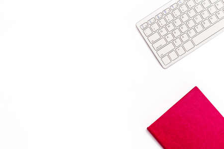 Pink diary and keyboard on a white background. Minimal feminine business concept. Flat lay. Top view.の写真素材