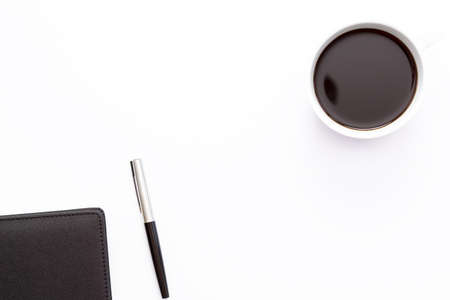 Cup of black coffee, diary and pen on a white background. Minimal business concept. Flat lay. Top view.の写真素材