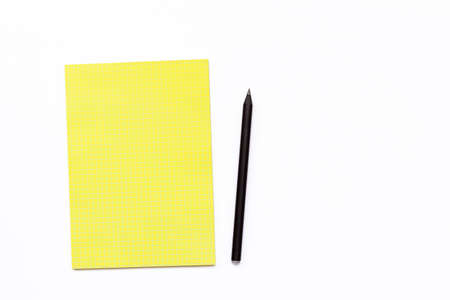 yellow notebook and black pencil on a white background. Minimal business concept for office. Flat lay. Top view.の写真素材