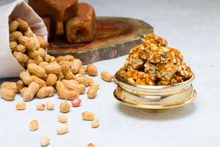 Peanut bar,crunchy sweet peanut bar which is very healthy and tasty snack,arranged on a white texture with a sack burlap of peanut and jaggery placed in background, selective focus.の写真素材