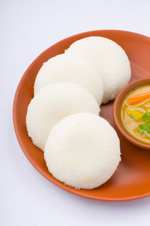 Idly or Idli, south indian main breakfast item which is beautifully arranged in an earthen ware with...