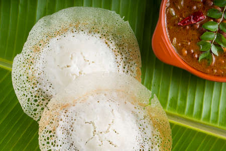 Appam or velliappam or kallappam  or paalappam, tasty delicious  breakfast item in south india and with a good combination of kadala curry or bengal gram curry ,placed on a banana leaf.の写真素材