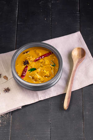 Chicken with raw banana curry (plantain),spicy chicken with green banana tastier indian dish arranged in a tableware which is on a tissue with black background.の写真素材