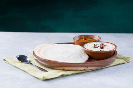 South Indian traditional  breakfast Dosa or Thattu dosa made using cast iron dosa thawa, arranged in...