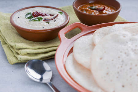South Indian traditional  breakfast Dosa or Thattu dosa made using cast iron dosa thawa, arranged in...