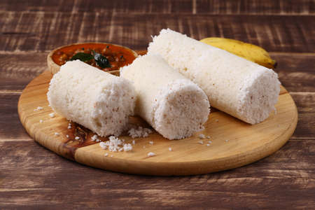 Puttu/Raw rice puttu/Arisi Maavu Puttu with chana curry/ kadala curry-Kerala special breakfast items made using raw rice flour, an ideal combination arranged in a wooden base with banana, on wooden background.の写真素材