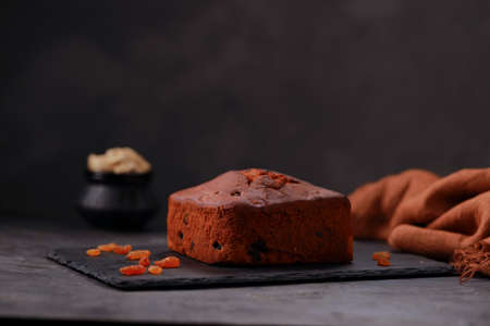 Plum cake, home made delicious christmus cake using raisins ,cashew nuts and dried fruits placed on a graphite base with grey colour background, isolated.の写真素材