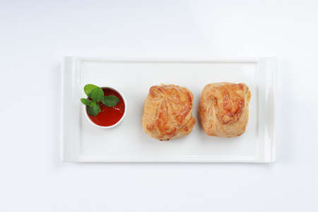 Egg Puff pastry filled with spicy and tasty egg masala and placed on a white tableware with tomato...