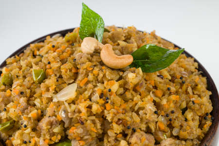 Aval upma or poha  upma or kanda poha upma,healthy indian breakfast item which is very tasty and easy to cook and it is arranged in a wooden bowl with white textured background.の写真素材