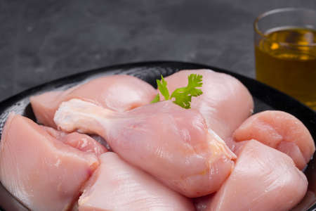Raw chicken biriyani cut without skin arranged on black container and garnished with coriander leaf and oil on  graphite colour background,close upの写真素材
