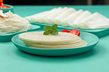 Rice Pathiri and Ideyappam, south indian malabar special breakfast made using rice flour which is white in colour, arranged in a aquamarine solid colour with beautifully garnished veg curry.の写真素材