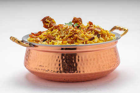 Chicken biryani , kerala style chicken dhum biriyani made using jeera rice and spices arranged in a brass serving bowl  with white background, isolatedの写真素材