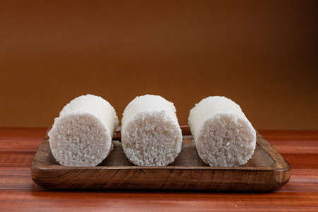 Puttu,steam cake,Arisi Maavu Puttu _breakfast item made using raw rice flour  arranged on a brown...
