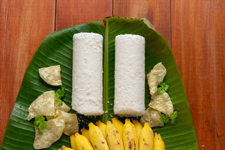 PUTTU /WHITE RICE PUTTU -Kerala special breakfast items made using rice flour which is arranged in traditional way with wooden backgroundの写真素材