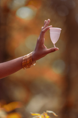 An Indian  teenage girl hand holding reusable silicon Menstrualcup,outdoor imagesの写真素材