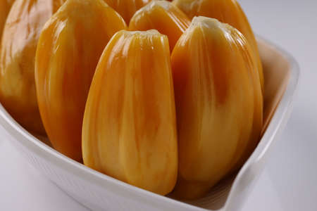 Ripe Jackfruit arranged beautifully in a white tableware  with white textured background,isolated.
