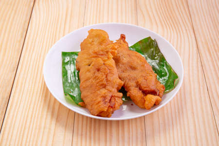 Banana fritters or banana fry or Pazham pori,Indian fried snack,isolated on ceramic plate  lined...