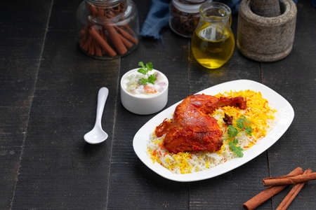 Chicken biryani or Tandoori chicken with basmathi rice and raita or raitha as side dish with black background or texture,selective focusの写真素材