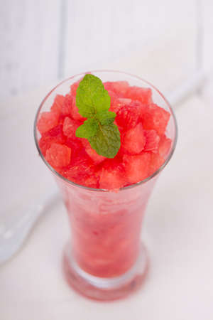 Watermelon mint juice ,cutpiece  of watermelon arranged in a white transparent glass with mint leaves arranged ina white background, isolated.の写真素材