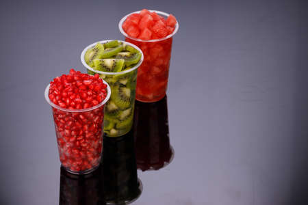 Watermelon , pomegrenate and Kiwi  Slices arranged  in two transparent glasses with white...