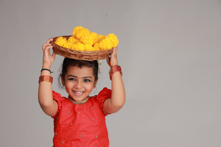 A cute small girl child wearing  Kerala dress-golden colour long skirt and red blouse,onam festival theme, isolated white background.の写真素材