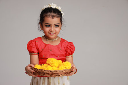 A cute small girl child wearing  Kerala dress-golden colour long skirt and red blouse,onam festival theme, isolated white background.の写真素材
