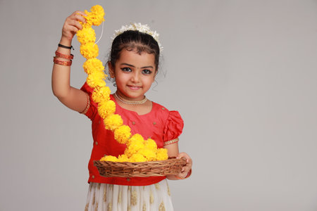 A cute small girl child wearing  Kerala dress-golden colour long skirt and red blouse,onam festival theme, isolated white background.の写真素材