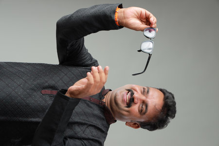 A man with Indian traditional costume, with plain background, isolated, wearing black kurta and white pyjama.の写真素材