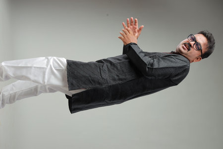 A man with Indian traditional costume, with plain background, isolated, wearing black kurta and...