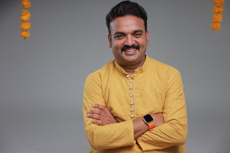 A man with Indian traditional costume, with plain background, isolated, wearing yellow kurta and...