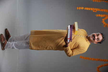 A man with Indian traditional costume, with plain background, isolated, wearing yellow kurta and white pyjama.の写真素材