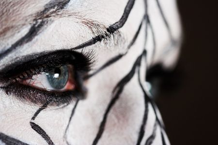 Face closeup of the girl having her face painted in the zebra-like patternの写真素材