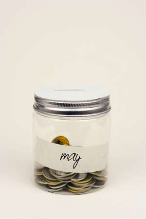 Coins in glass jar for monthly savingの写真素材