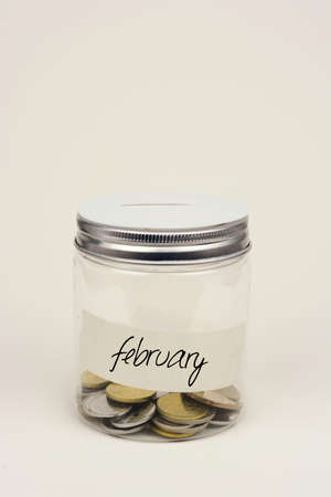 Coins in glass jar for monthly savingの写真素材