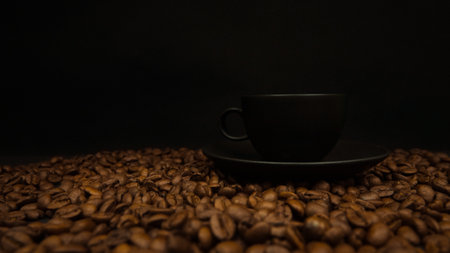 a cup of espresso on a black background and roasted coffee beans underneath. coffee banner conceptの写真素材