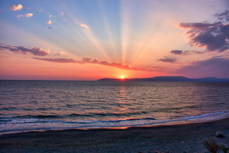 Beautiful Aegean sunset over Seferihisar Izmir with an orange evening sky and light reflected in a...