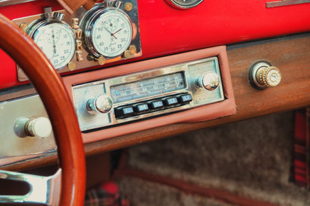 Steering wheel and dashboard of an old red car, vintage style.の写真素材