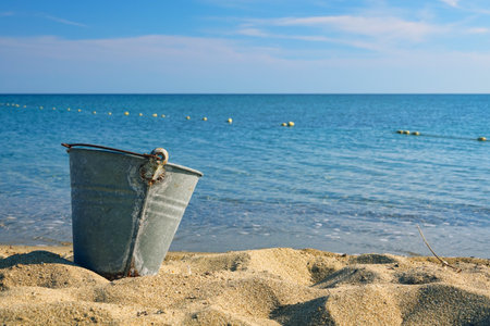 Bucket on the beach with blue sea and blue sky background.の写真素材