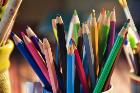 colorful wooden crayons stand vertically in pencil holder box. colored pencils in a vase on a wooden table, selective focus. Back to school conceptの写真素材