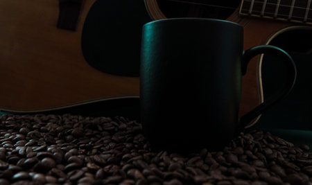 Coffee beans, guitar and cup of coffee on dark backgroundの写真素材
