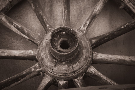 Old wooden wheel of an old wagon on a gray background. Toned.の写真素材