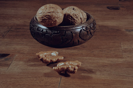 Walnuts in a wooden bowl on a wooden background. Toned.の写真素材