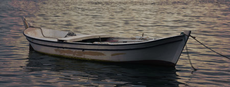 Fishing boat on the lake in the morning light. Close-up.